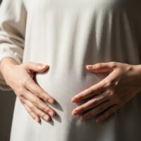 お腹が張って苦しむ女性